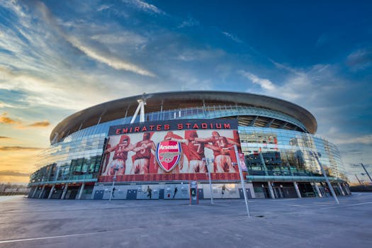 View of Emirates Stadium, home of Arsenal FC in London, showcasing modern architecture under a vibrant sky.