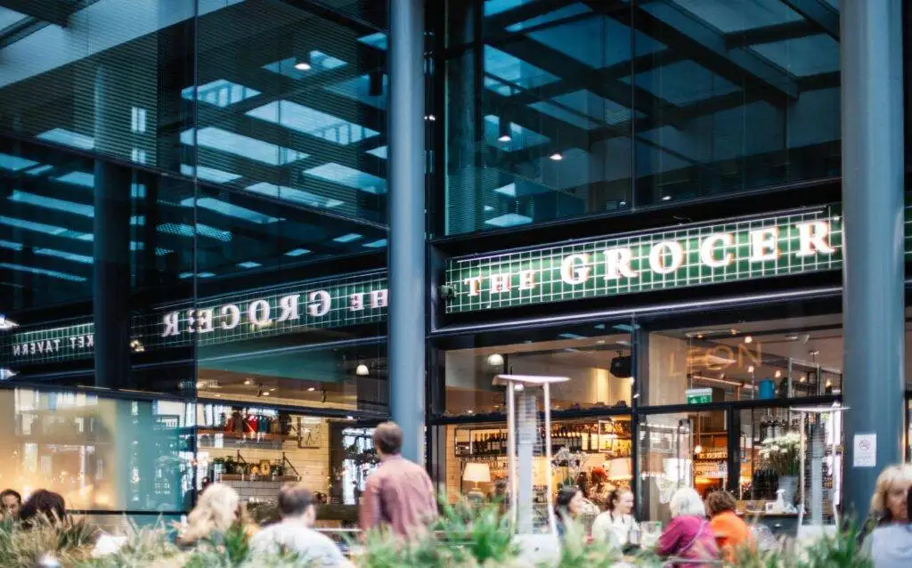 A bustling grocery store with a modern design and visible clientele.