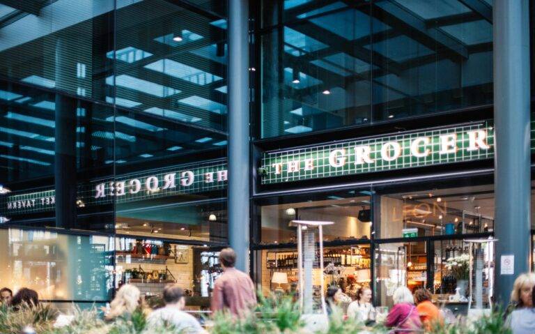A bustling grocery store with a modern design and visible clientele.