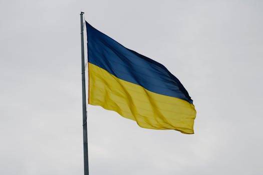Ukrainian national flag waving against a cloudy sky, symbolizing national pride.
