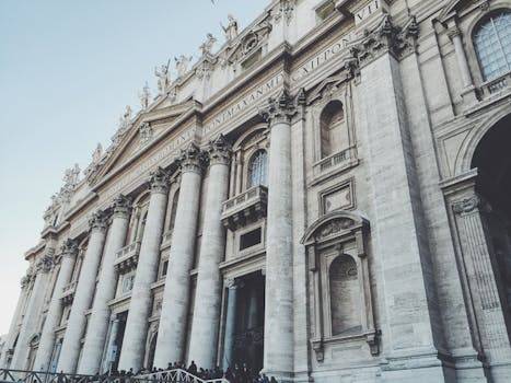 View of the stunning stone facade and grand columns of St. Peter's Basilica in Vatican City, a masterpiece of Renaissance architecture.